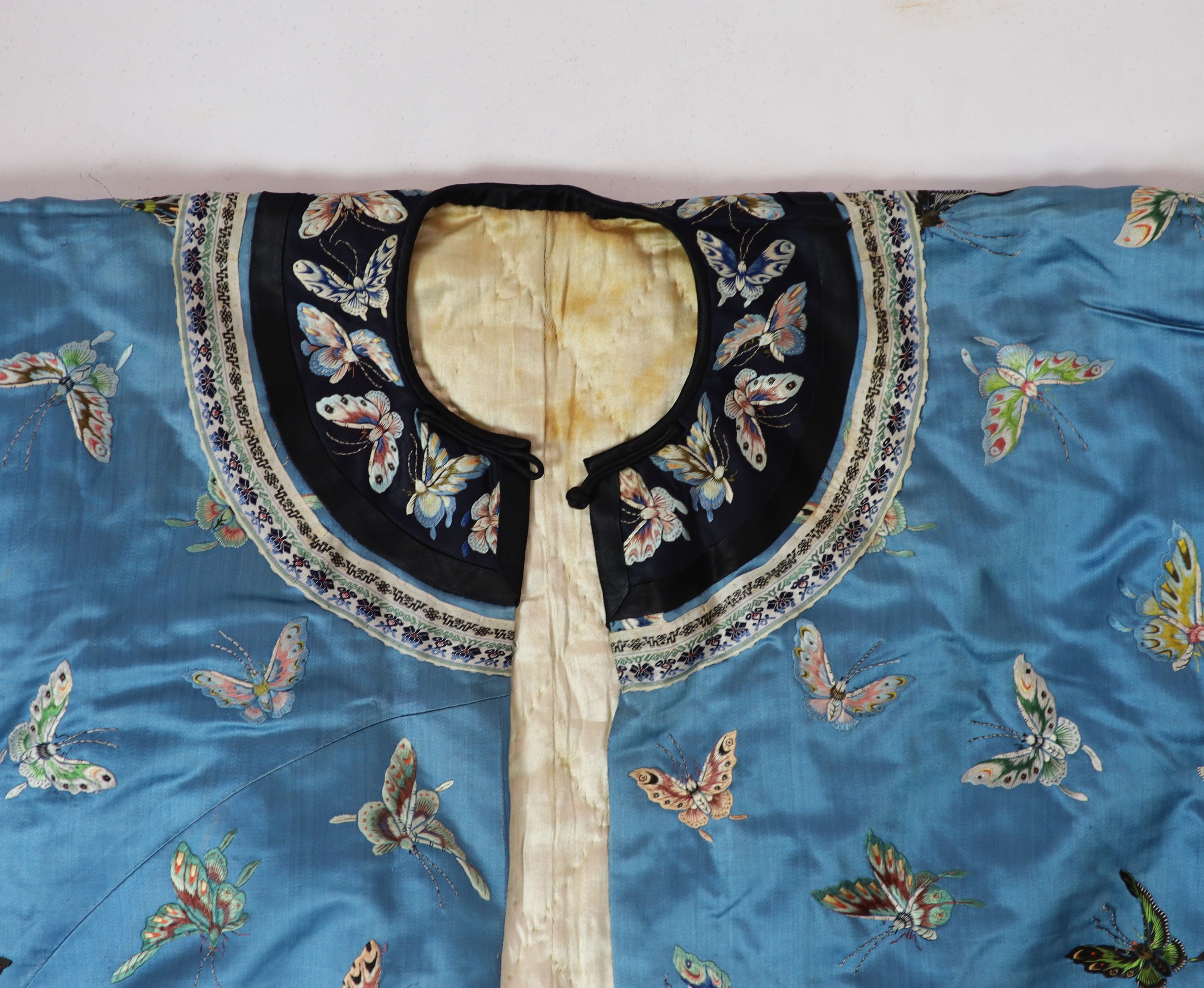 A Chinese blue silk ‘butterfly’ Winter robe, late 19th century, 132cm drop